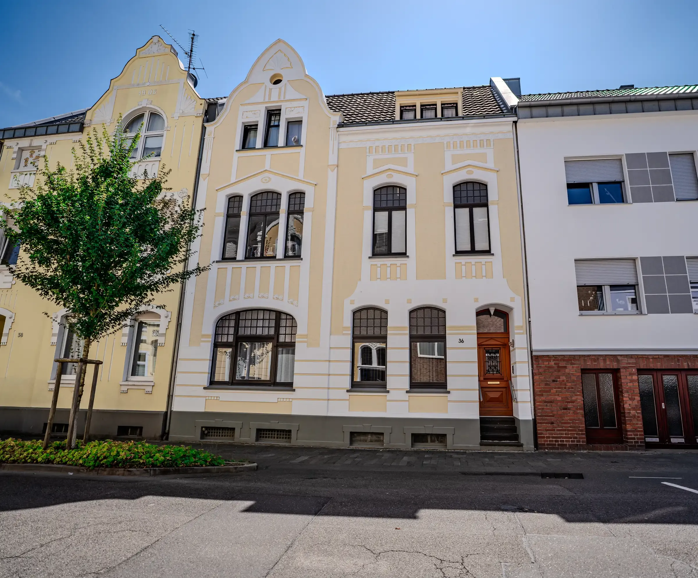 Straßenansicht mit jungen Bäumen und angrenzender Bebauung