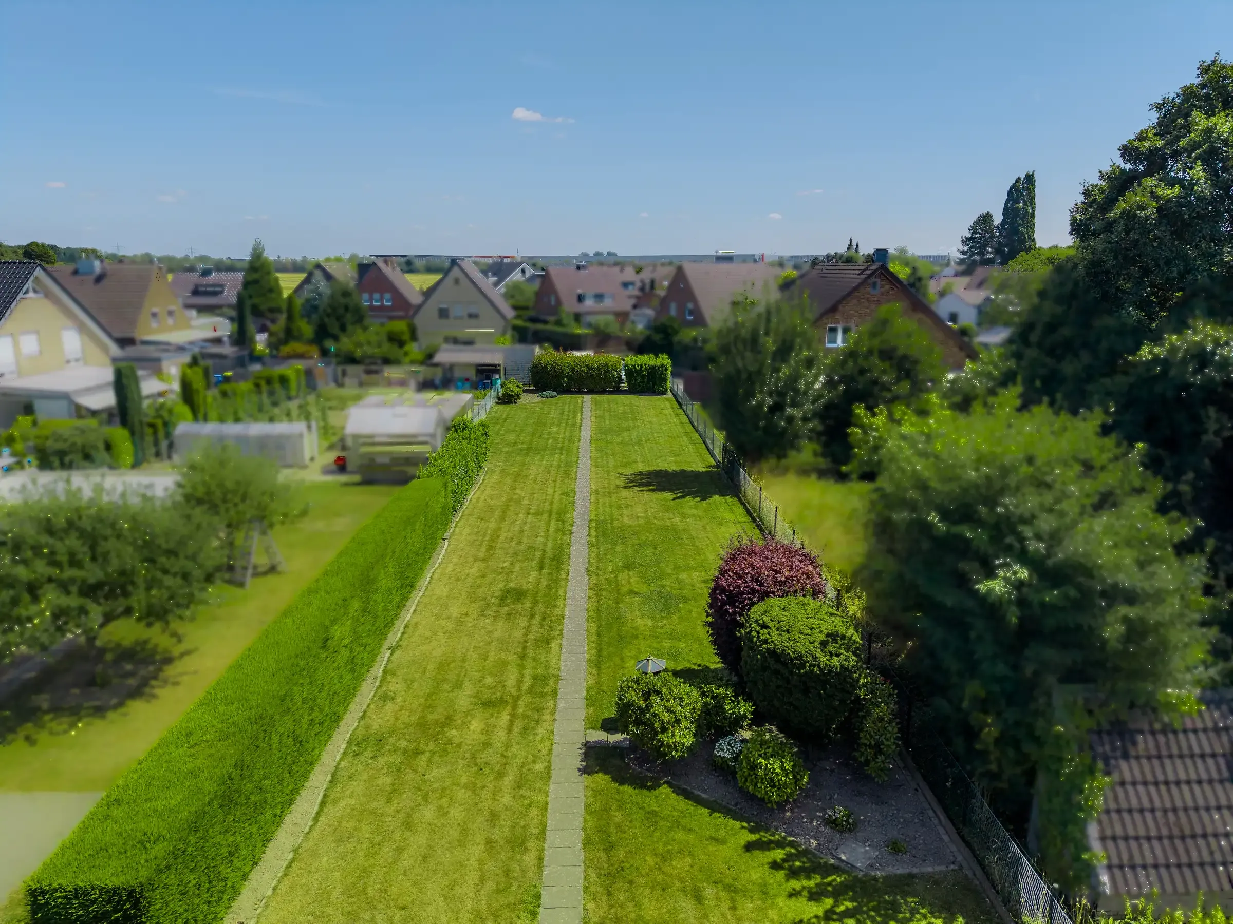 Langgestrecktes Wiesengrundstück zwischen gepflegten Nachbargärten in Wickrathberg