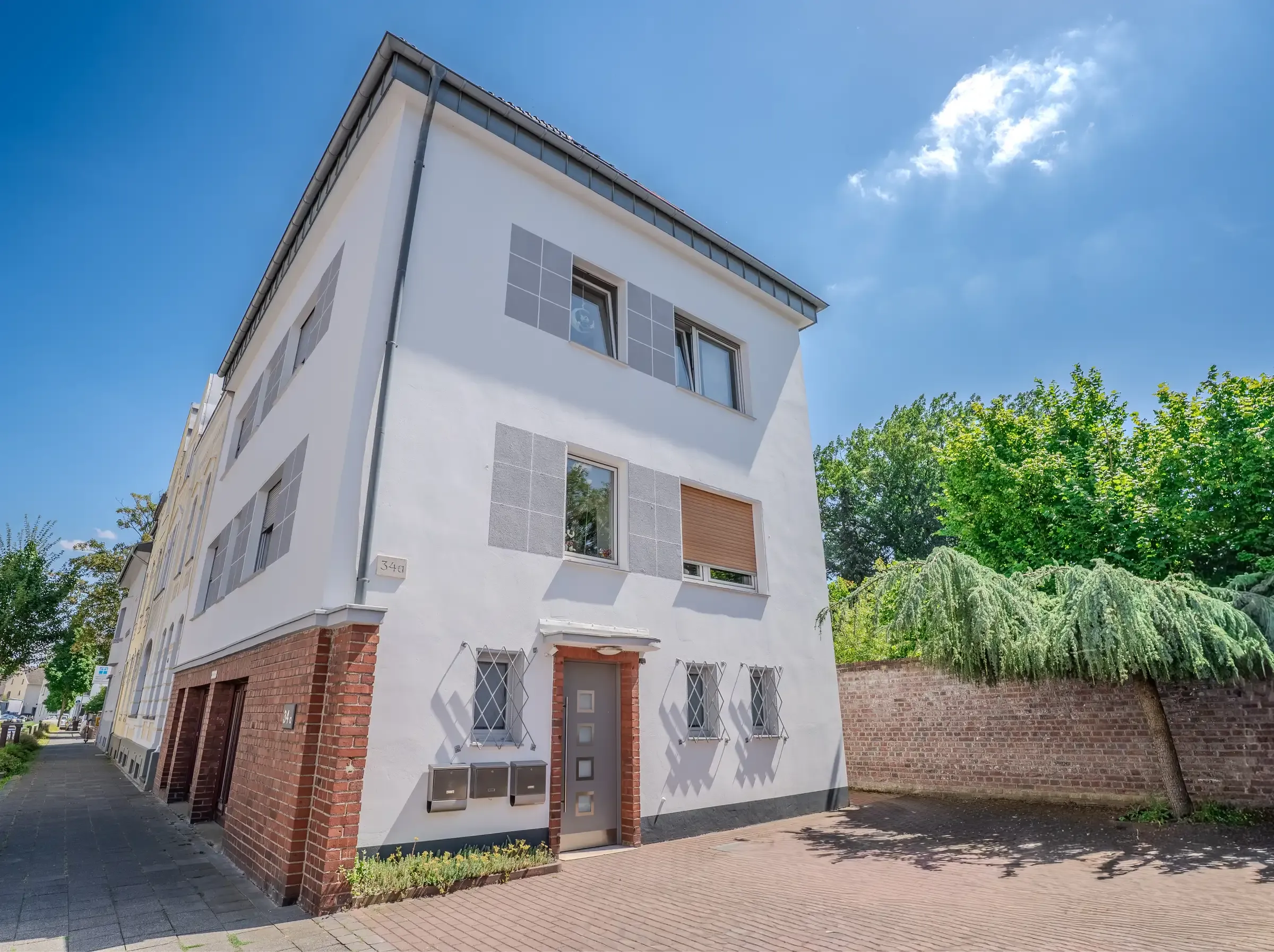 Eingangsseite mit erhöhtem Hauseingang und gepflastertem Vorplatz