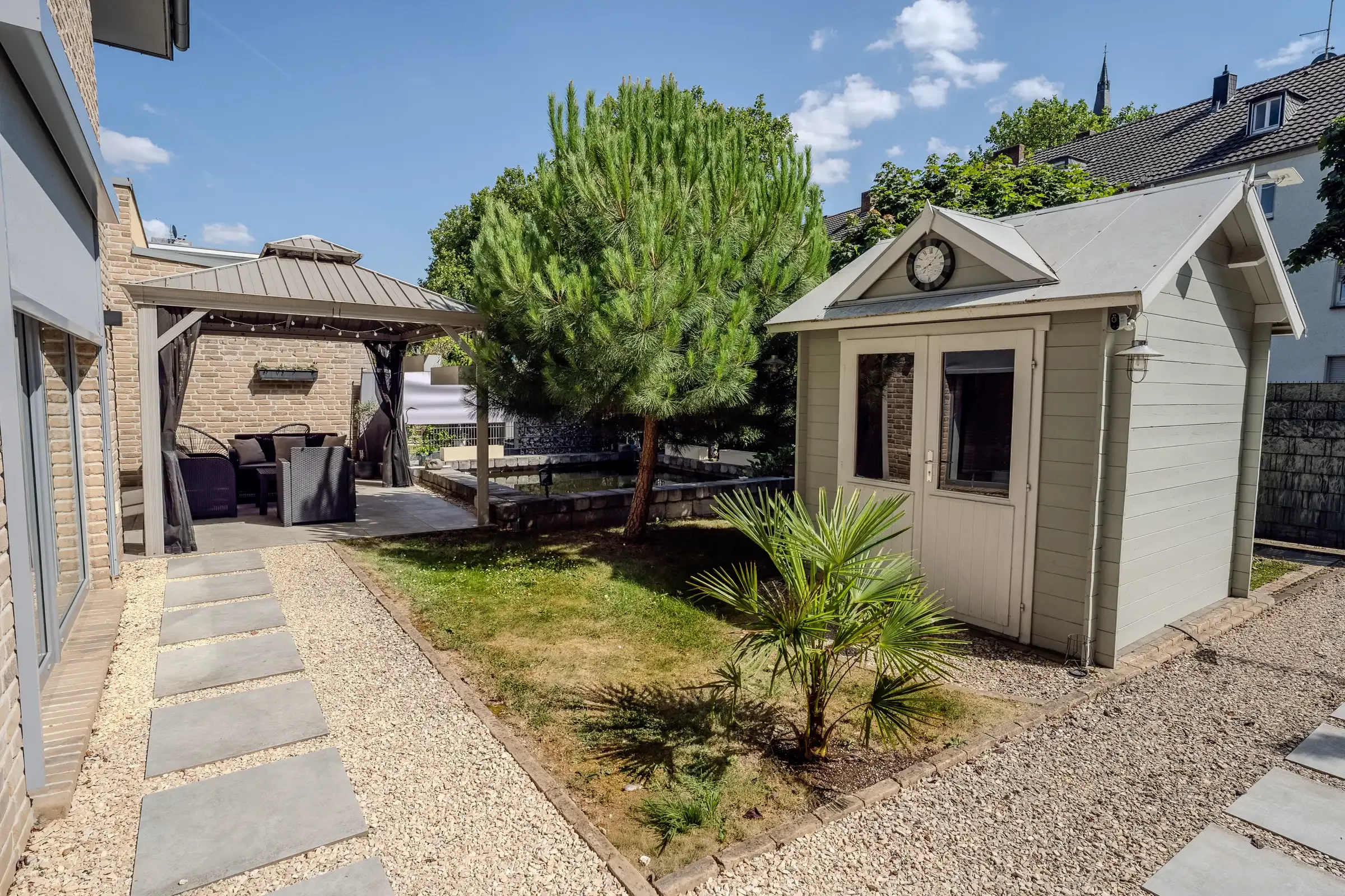 Geschützter Gartenhof mit Pavillon, Gartenhaus und mediterraner Bepflanzung
