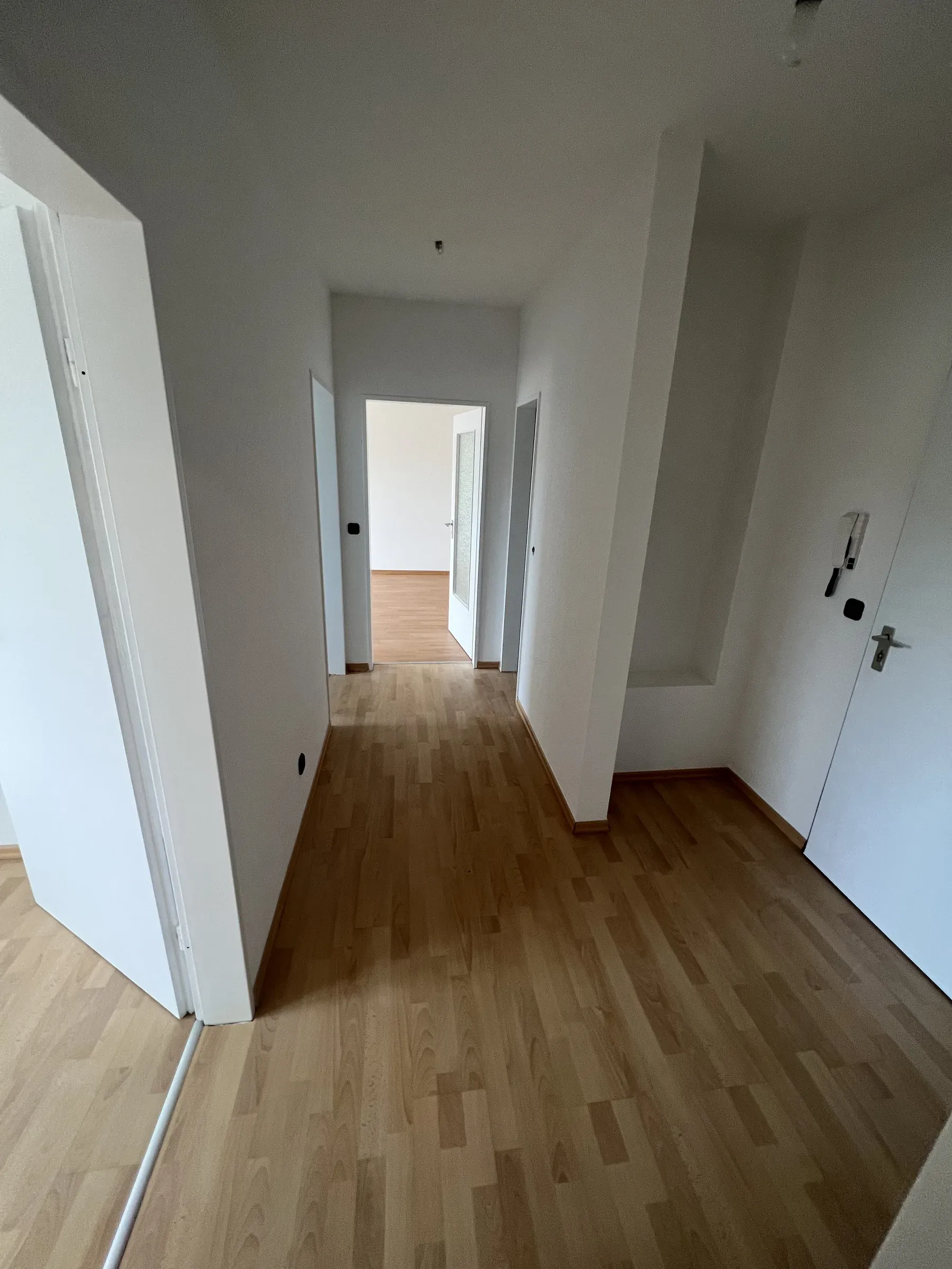 Flur mit Holzboden und Blick durch die geöffneten Zimmertüren