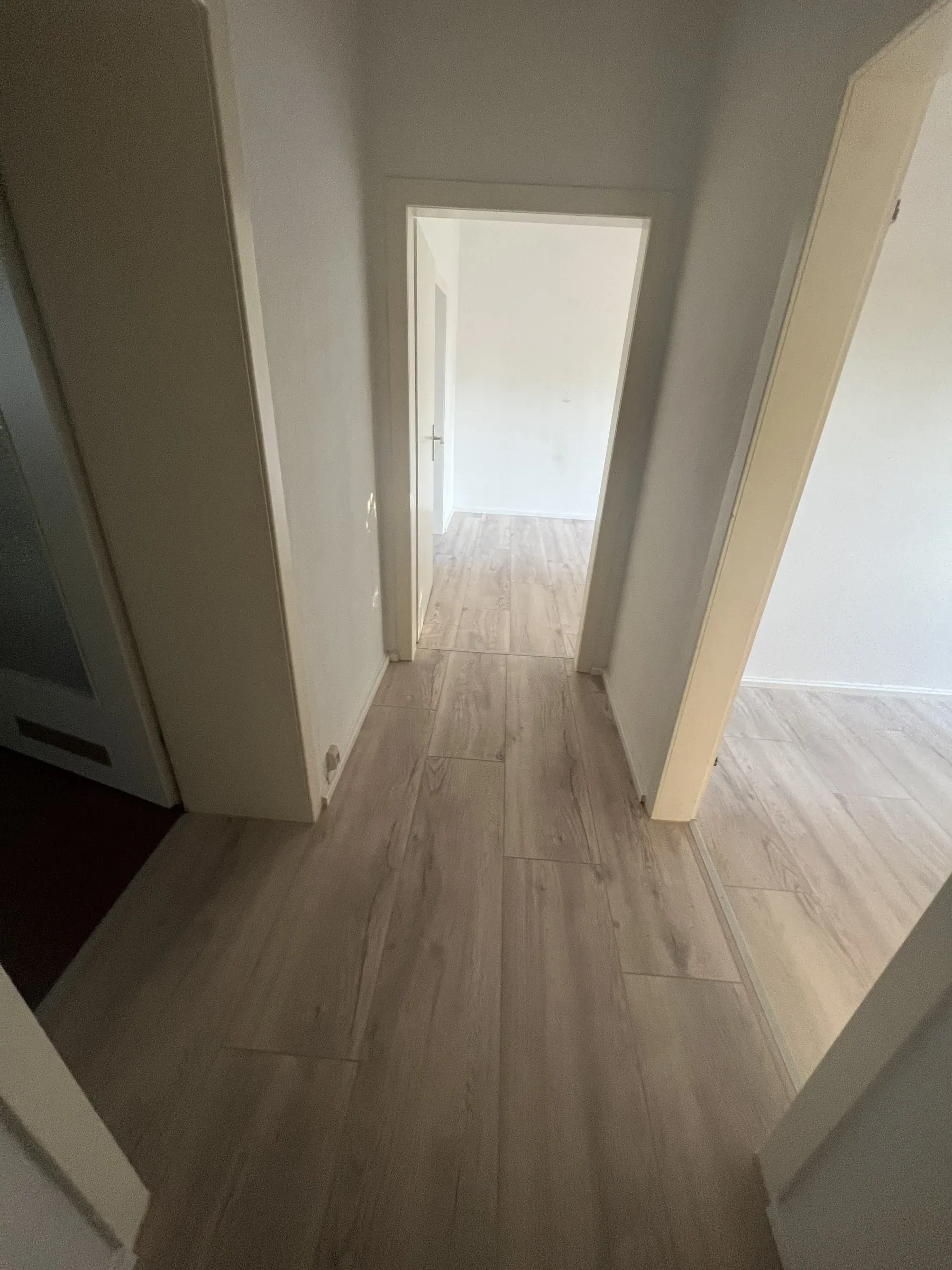 Flur mit durchgehendem Bodenbelag und Blick in den nächsten Raum